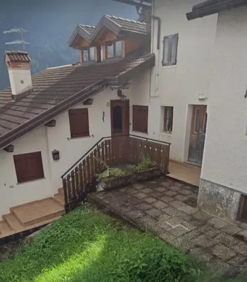a house with a wooden fence in front of it at Dolomites Holiday Home in Rivamonte