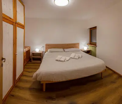 a bedroom with a bed with two pillows on it at Appartamento Martino in San Martino di Castrozza