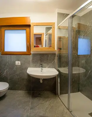 a bathroom with a sink and a shower at Appartamento Martino in San Martino di Castrozza