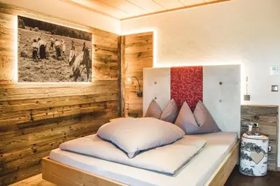 a bed in a room with wooden walls at Kirchwies Naturchalet - Adults Only in Laion