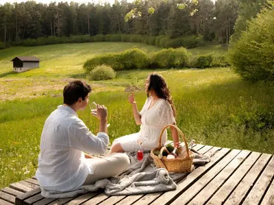 a man and a woman sitting on a picnic table at Kirchwies Naturchalet - Adults Only in Laion