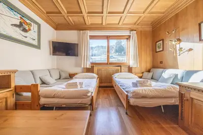 a living room with a couch and a table at Casa Ronco, tranquilla e confortevole in Cortina dʼAmpezzo
