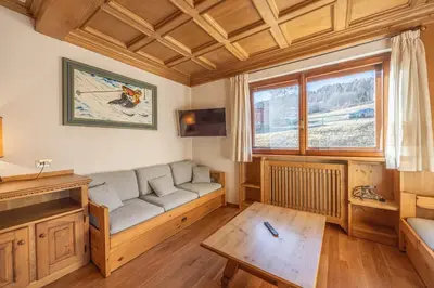 a living room with a couch and a window at Casa Ronco, tranquilla e confortevole in Cortina dʼAmpezzo