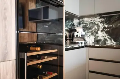 a kitchen with a refrigerator filled with wine bottles at DISTINCTIVE LUXURY DOLOMITI Apartments TERRE71 in San Vigilio Di Marebbe