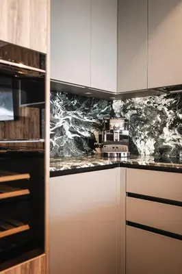 a kitchen with marble counter tops and white cabinets at DISTINCTIVE LUXURY DOLOMITI Apartments TERRE71 in San Vigilio Di Marebbe