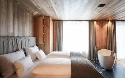 a bedroom with a large bed and a window at DISTINCTIVE LUXURY DOLOMITI Apartments TERRE71 in San Vigilio Di Marebbe
