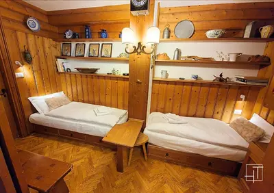 two beds in a room with wooden walls at HT - Ciasa Ca'Mora nel centro di Cortina d'Ampezzo in Cortina dʼAmpezzo