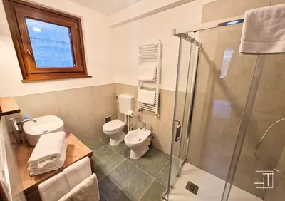 a bathroom with a shower and a toilet and a sink at HT - Ciasa Ca'Mora nel centro di Cortina d'Ampezzo in Cortina dʼAmpezzo