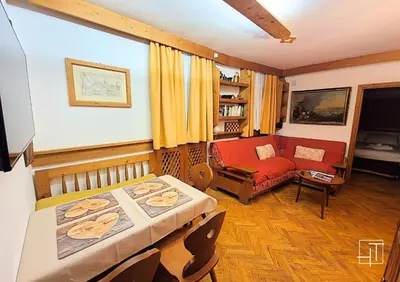 a living room with a bed and a couch at HT - Ciasa Ca'Mora nel centro di Cortina d'Ampezzo in Cortina dʼAmpezzo