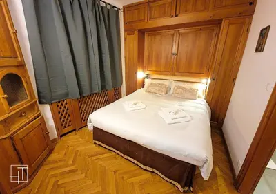 a bedroom with a bed with wooden walls and a window at HT - Ciasa Ca'Mora nel centro di Cortina d'Ampezzo in Cortina dʼAmpezzo