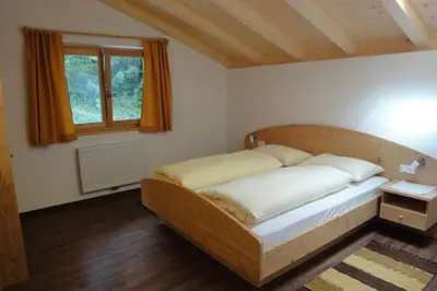 a bedroom with a wooden bed in a room at Haus Grünfeld in Santa Valburga St. Walburg