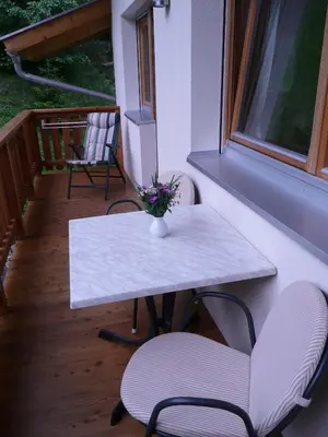 a table and chairs on a balcony with a table and flowers at Haus Grünfeld in Santa Valburga St. Walburg