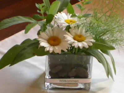 a vase filled with white flowers sitting on a table at Haus Grünfeld in Santa Valburga St. Walburg
