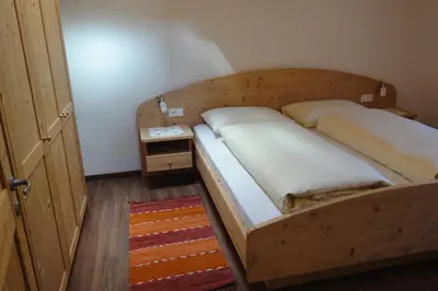 a bedroom with a wooden bed and a night stand at Haus Grünfeld in Santa Valburga St. Walburg