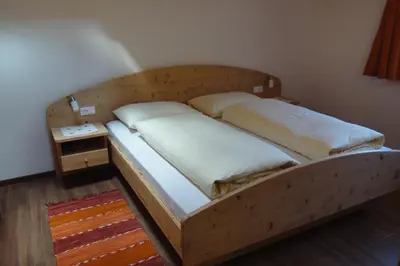 a bed in a room with a wooden frame at Haus Grünfeld in Santa Valburga St. Walburg