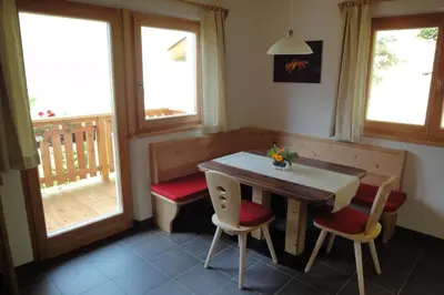 a dining room with a table and two windows at Haus Grünfeld in Santa Valburga St. Walburg