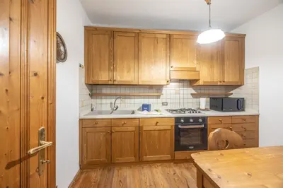 a kitchen with wooden cabinets and a sink at Casa Zardini, in centro a Cortina d'Ampezzo in Cortina dʼAmpezzo