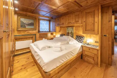 a bedroom with a bed in a room with wooden walls at Chiara Home, in centro a Cortina d Ampezzo in Cortina dʼAmpezzo