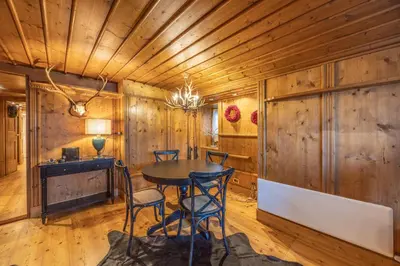 a dining room with wooden walls and a table and chairs at Chiara Home, in centro a Cortina d Ampezzo in Cortina dʼAmpezzo
