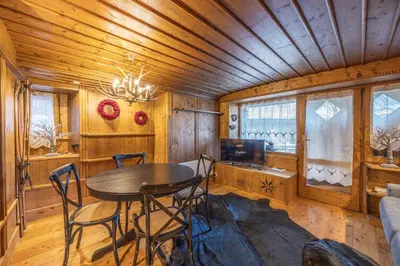 a dining room with a table and chairs in a cabin at Chiara Home, in centro a Cortina d Ampezzo in Cortina dʼAmpezzo