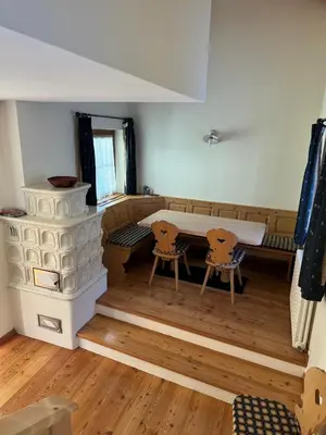 a room with a fireplace and a table and chairs at Cèsa Emily in Campitello di Fassa