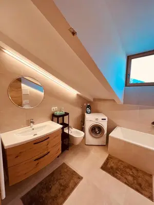 a bathroom with a sink and a washing machine at Apartment Ploseblick in Bressanone