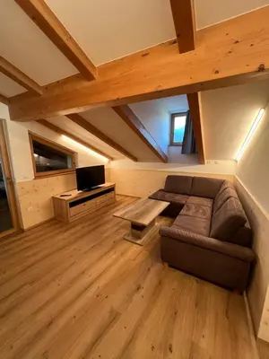 a living room with a couch and a tv at Apartment Ploseblick in Bressanone
