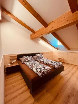 a large bed in a room with wooden floors at Apartment Ploseblick in Bressanone