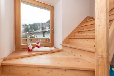 a staircase with two stuffed animals sitting in front of a window at Ciesa dela Maestra in Rocca Pietore