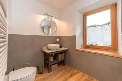 a bathroom with a sink and a window at Ciesa dela Maestra in Rocca Pietore