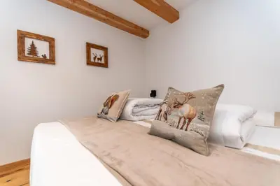 a bedroom with a bed with two deer pillows at Ciesa dela Maestra in Rocca Pietore