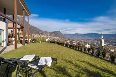 a balcony with chairs and a view of a city at HOMESTWENTY3 - Home six in Caldaro