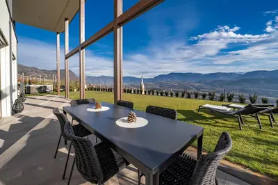 a table and chairs on a patio with a view at HOMESTWENTY3 - Home six in Caldaro