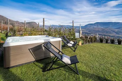 a hot tub and two chairs sitting in the grass at HOMESTWENTY3 - Home six in Caldaro