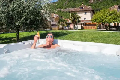 a man in a hot tub holding a banana at Garni Gartenheim in Caldaro