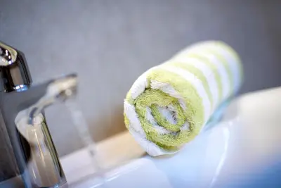 a towel sitting on a sink next to a faucet at Garni Gartenheim in Caldaro