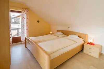 a bedroom with a large bed and a window at Garni Gartenheim in Caldaro