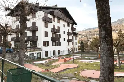 a large white building with balconies on it at GuestHost - Cortina Heart Retreat with Parking in Cortina dʼAmpezzo