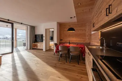 a kitchen and dining room with a table and chairs at A-Lunis in Brunico