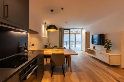 a kitchen with a wooden table and a dining room at A-Lunis in Brunico