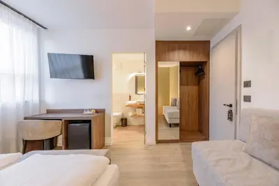a living room with a bed and a room with a table at NAOMI Rooms in Salorno sulla Strada del Vino