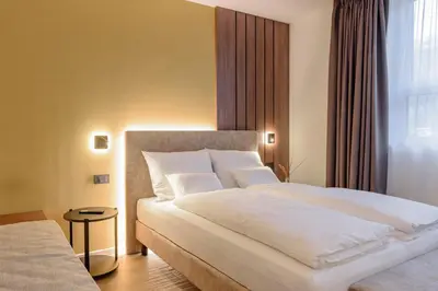 a bedroom with a large white bed and a window at NAOMI Rooms in Salorno sulla Strada del Vino