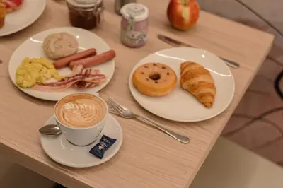 a table with plates of breakfast foods and a cup of coffee at NAOMI Rooms in Salorno sulla Strada del Vino