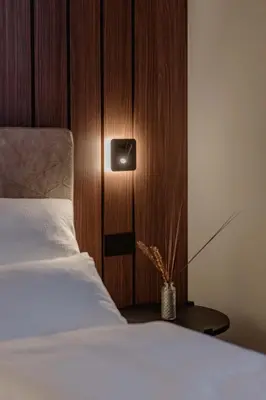 a bedroom with a white bed and a wooden wall at NAOMI Rooms in Salorno sulla Strada del Vino