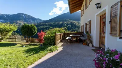a porch of a house with a table and a fence at Spinuserhof in Tires