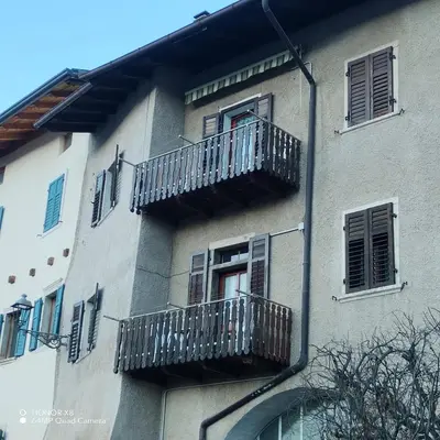 a building with two balconies on the side of it at Appartamento vacanze Tres - Predaia in Tres