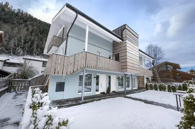 a house in the snow with snow covered grounds at Apartments No7 Sella in Ortisei