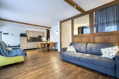a living room with a couch and a kitchen at Apartments No7 Sella in Ortisei