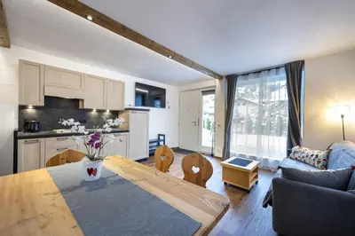a kitchen and living room with a table and a couch at Apartments No7 Saslong in Ortisei
