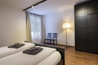 a bedroom with two beds and a lamp and a window at Apartments No7 Saslong in Ortisei